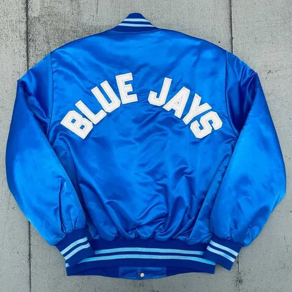 Blue jacket with 'BLUE JAYS' text on a concrete surface
